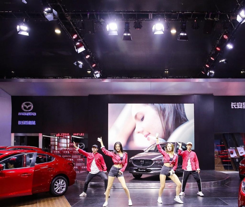 Dance ensemble performing on a manufacturer's stand at a Chinese motor show