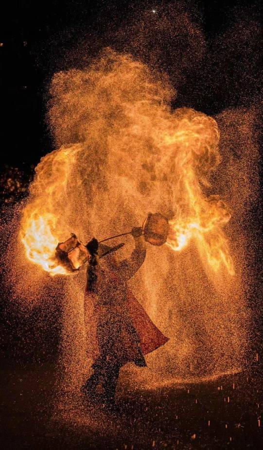Fire pot 火壶 performer spinning burning charcoal on a chain at night